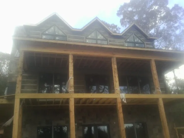 Dormers and porch framing on a large log home under construction — Roof Coating work by our crew in The Dalles