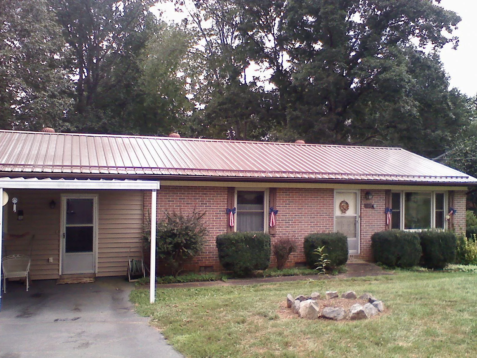 Bronze metal roof and carport on a brick ranch home — Roof Repair work by our crew in The Dalles